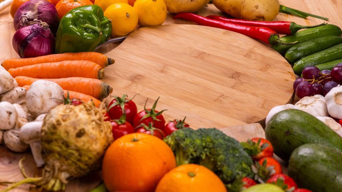Vibrant variety of fresh fruits and vegetables on a wooden table for healthy eating.